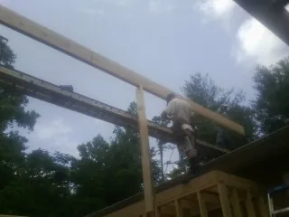 Carpenter setting a ridge beam over a new addition frame — Ice Dam Removal by Roofing Brothers in Beaver